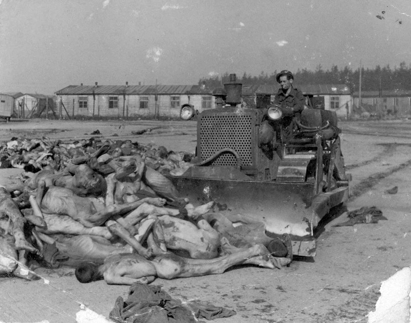 Британский солдат на бульдозере собирает трупы узников концлагеря Берген-Бельзен.